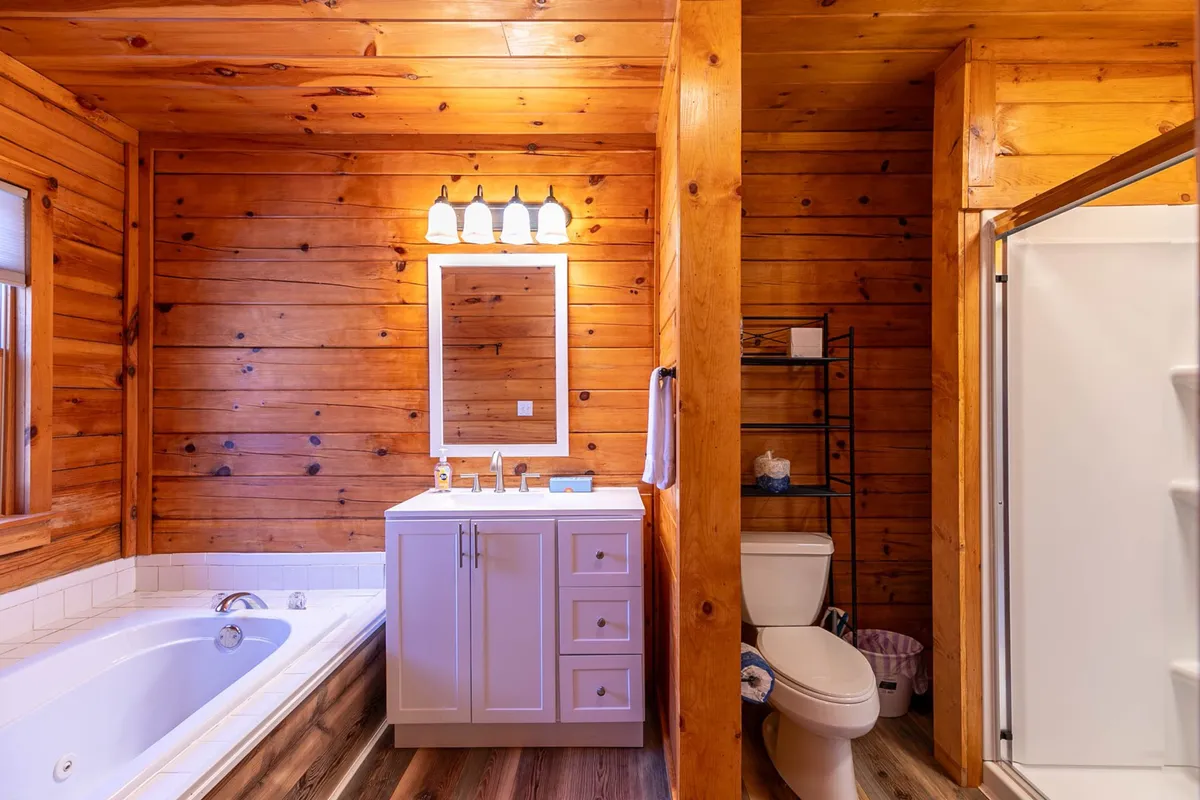 A modern bathroom complete with a bathtub, vanity with a large mirror, and a separate shower stall, all designed for relaxation and self-care.
