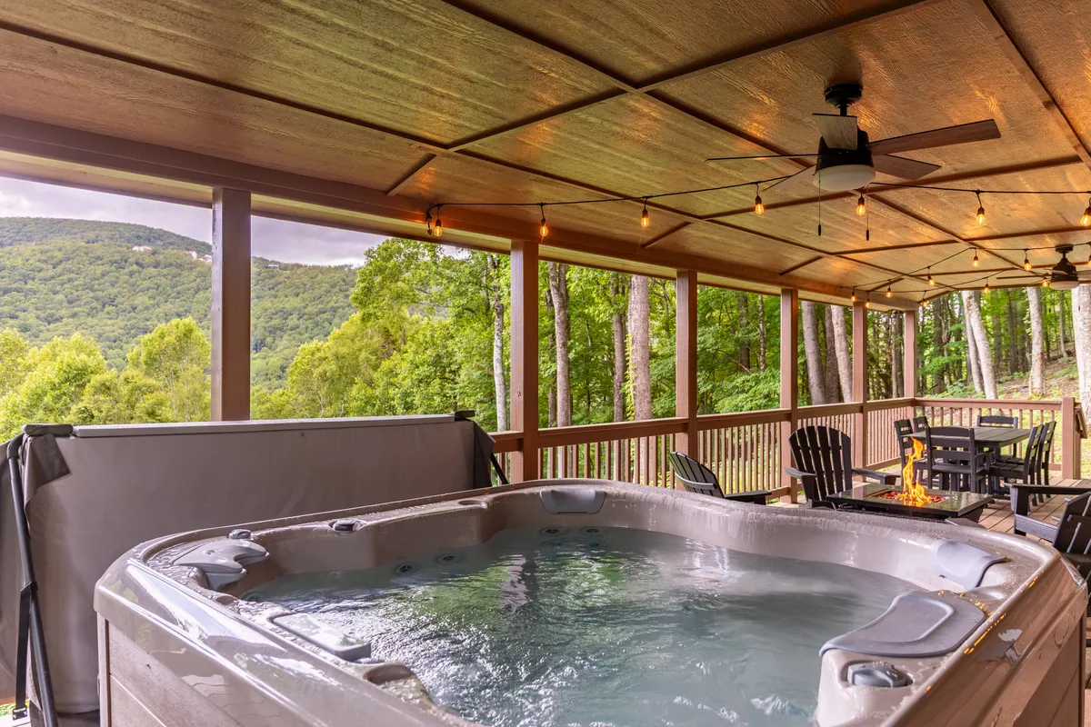 A tranquil outdoor setting with a hot tub, a fire pit with comfortable seating, and sweeping mountain views. The arrangement is oriented to maximize enjoyment of both the amenities and the landscape, emphasizing the peaceful and expansive three-acre property.